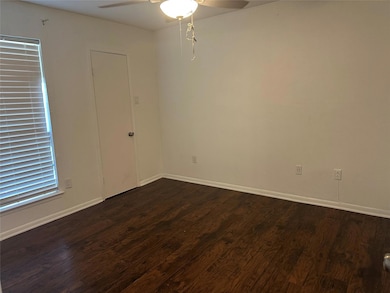 Unfurnished room featuring ceiling fan and dark w
