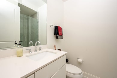 Full bathroom featuring a shower stall, vanity, toilet, and baseboards
