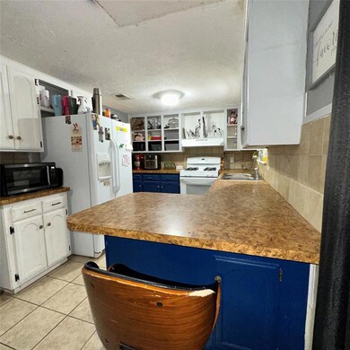 Kitchen featuring backsplash, white cabinetry, whi