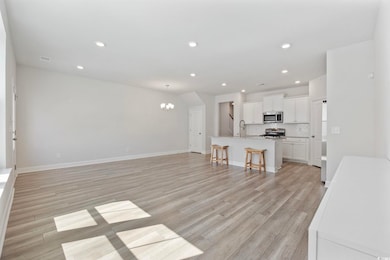 Unfurnished living room with recessed lighting, light wood-style floors, and a chandelier