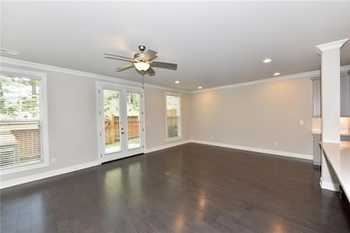 Unfurnished living room with crown molding, basebo