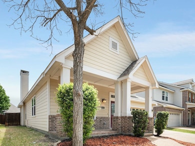 View of front facade featuring brick siding, covered porch, and concrete driveway