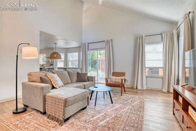 Living room with light wood-type flooring, high va