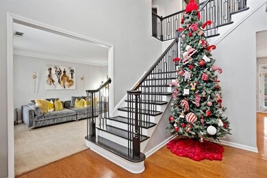 Staircase featuring wood finished floors and a high ceiling