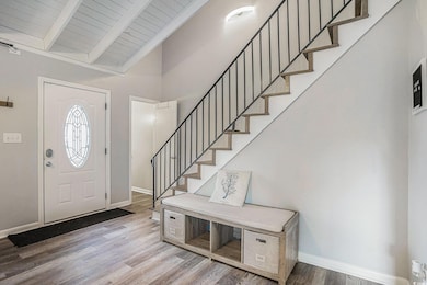 Foyer entrance with wood finished floors, stairway, and wooden ceiling