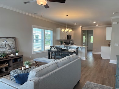 Living area featuring baseboards, a chandelier, pl