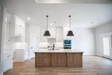 Kitchen featuring stainless steel oven, black microwave, light wood-type flooring, light countertops, and recessed lighting