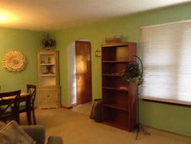 Nice size living room with hardwood under carpet.