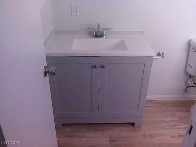 Half bath featuring vanity and wood finished floors