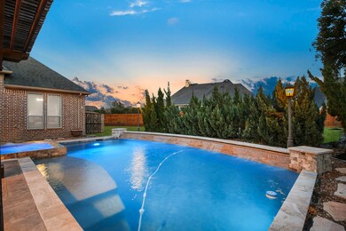 Rectangle pool features a custom waterfall. This is an AMAZING backyard.