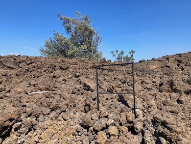 The lot is to the left of the sign holder