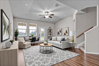 Living room featuring stairway, light wood-type flooring, recessed lighting, a ceiling fan, and vaulted ceiling