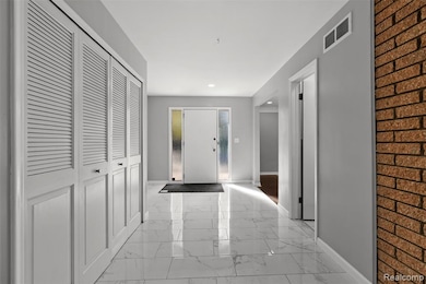 Corridor with light marble finish flooring and recessed lighting
