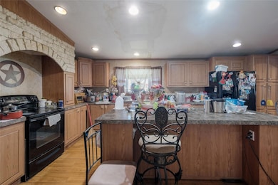 Kitchen with black appliances, a breakfast bar ar