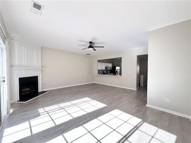 Unfurnished living room featuring ceiling fan, light wood-type flooring, and a fireplace
