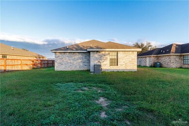 Back of property featuring a yard and central AC