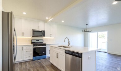 Kitchen featuring appliances with stainless steel finishes, recessed lighting, dark wood finished floors, and white cabinetry