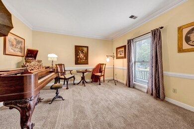 Living area with ornamental molding and carpet