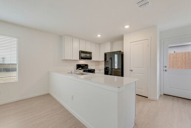 Kitchen with light wood-style floors, visible vents, a peninsula, and black appliances
