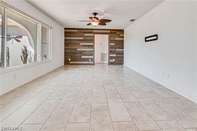 Tiled empty room with ceiling fan and wood walls