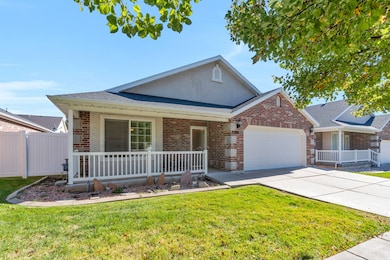 Single story home featuring a porch, roof with shingles, driveway, brick siding, and a garage