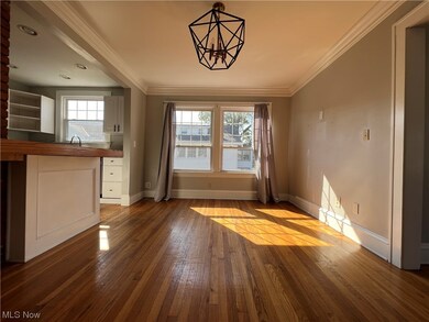 Unfurnished living room featuring ornamental molding, a notable chandelier, sink, and wood-type flooring