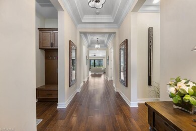 Corridor with an inviting chandelier, a tray ceili