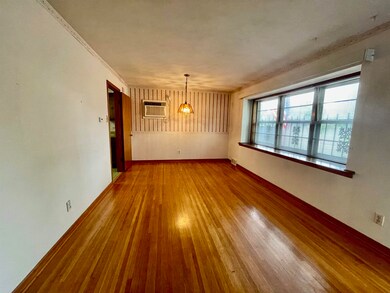 Unfurnished living room featuring an AC wall unit,