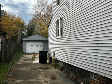 View of property exterior with a detached garage, driveway, and an outdoor structure