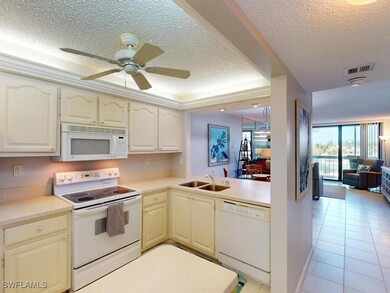 Kitchen featuring white appliances, a textured cei