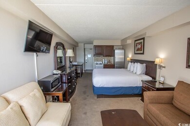Bedroom featuring freestanding refrigerator, light