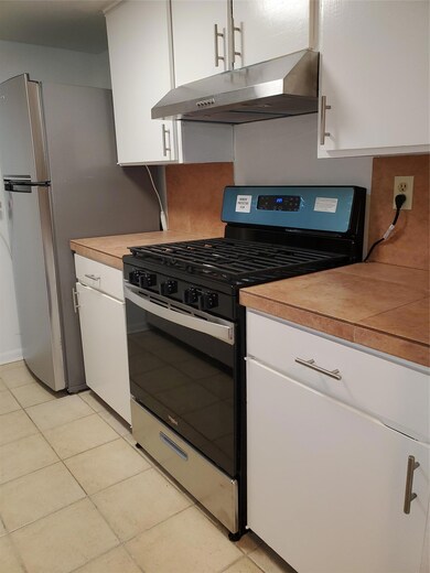 Kitchen featuring gas range, ventilation hood, wh