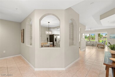 Hallway featuring light tile patterned floors and a chandelier
