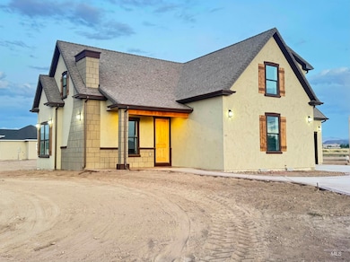 View of front of home featuring roof with shingles and stucco siding