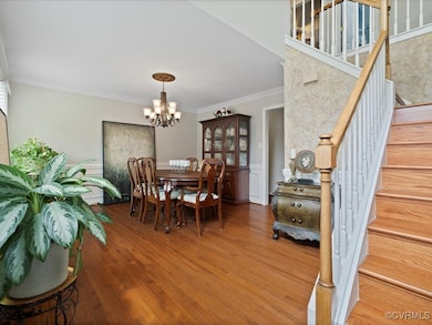 Dining space with a chandelier, crown molding, sta