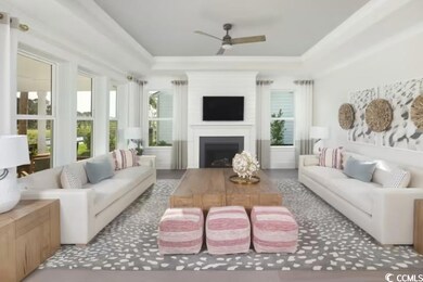 Living room featuring a ceiling fan, a tray ceilin