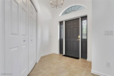 Entrance foyer featuring light tile patterned flooring, a chandelier, and a high ceiling