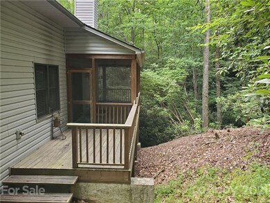Rear screened porch steps down to the ground in th