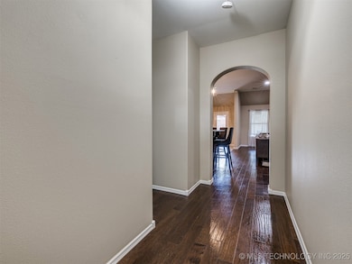 Corridor with arched walkways, dark wood-style flo