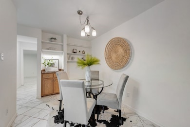 Dining area featuring light tile flooring, a dry bar and  chandelier