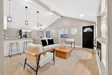 Living room with beam ceiling, light wood-style floors, and high vaulted ceiling