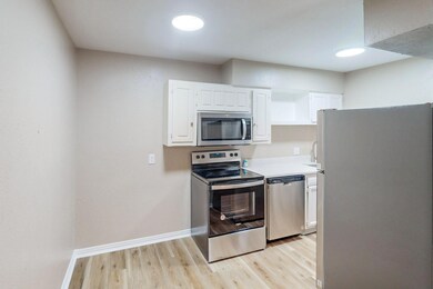 Kitchen featuring light hardwood / wood-style flooring, stainless steel appliances, and white cabinets