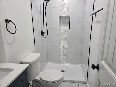 Full bathroom with toilet, a stall shower, and van