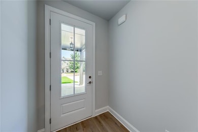Doorway with wood finished floors and baseboards