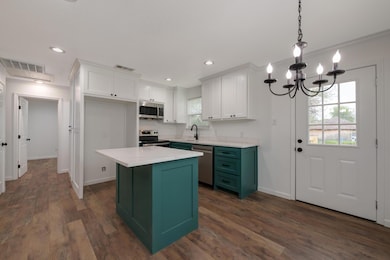 Kitchen featuring white cabinets, stainless steel 