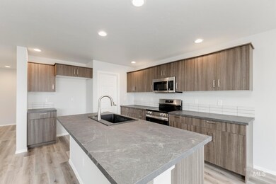 Kitchen featuring modern cabinets, appliances with stainless steel finishes, light wood-type flooring, recessed lighting, and an island with sink