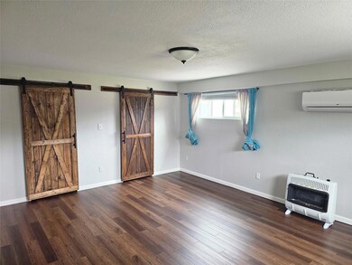 Unfurnished bedroom featuring heating unit, a wal