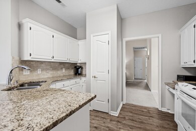 Kitchen with white cabinets, a textured ceiling, d