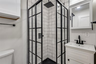 Full bath with a walk in shower, vanity, and toile