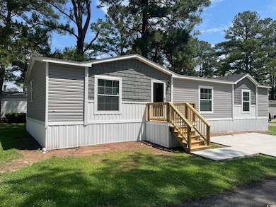 Manufactured / mobile home with a front lawn and a patio area